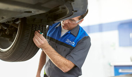 Photo of a mechanic inspecting a tire.